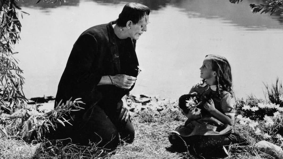 Imagem de Frankenstein (1931). O monstro (no seu visual clássico, com parafusos no pescoço) colhe flores junto com uma menininha em frente a um lago